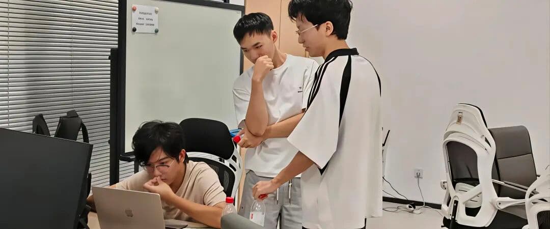 参与者围在笔记本电脑前讨论